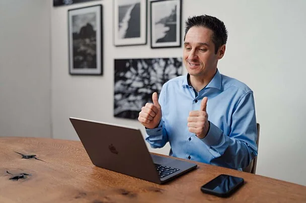 Alex Pippir sitzt am Laptop und zeigt beide Daumen nach oben – Bild aus dem Beitrag auf FOCUS online