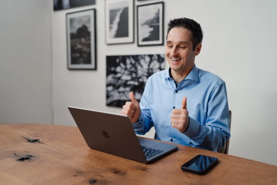 Alex Pippir zeigt am Laptop beide Daumen nach oben