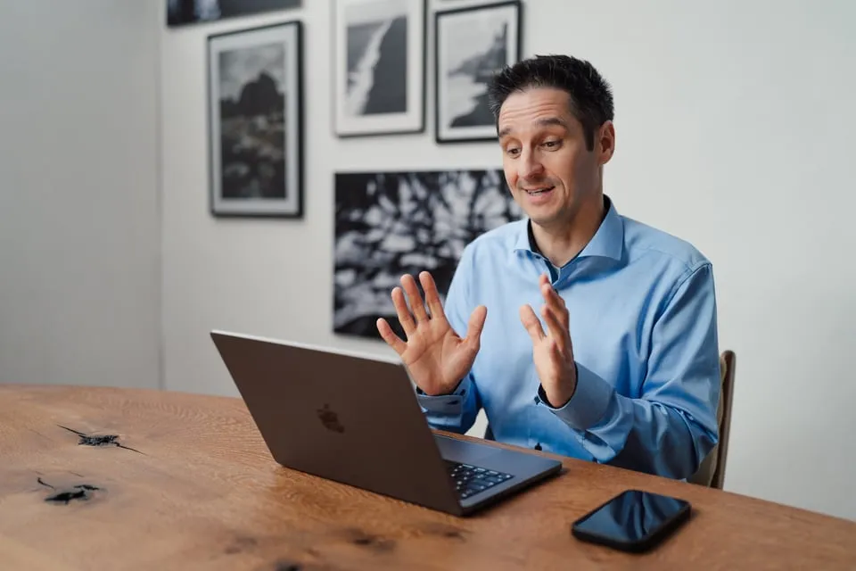 Alex Pippir erklärt am Laptop mit offenen Händen