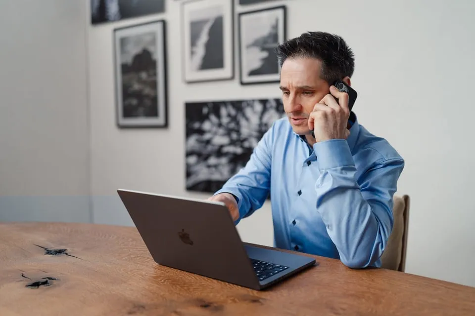 Alex Pippir telefoniert nachdenklich am Laptop