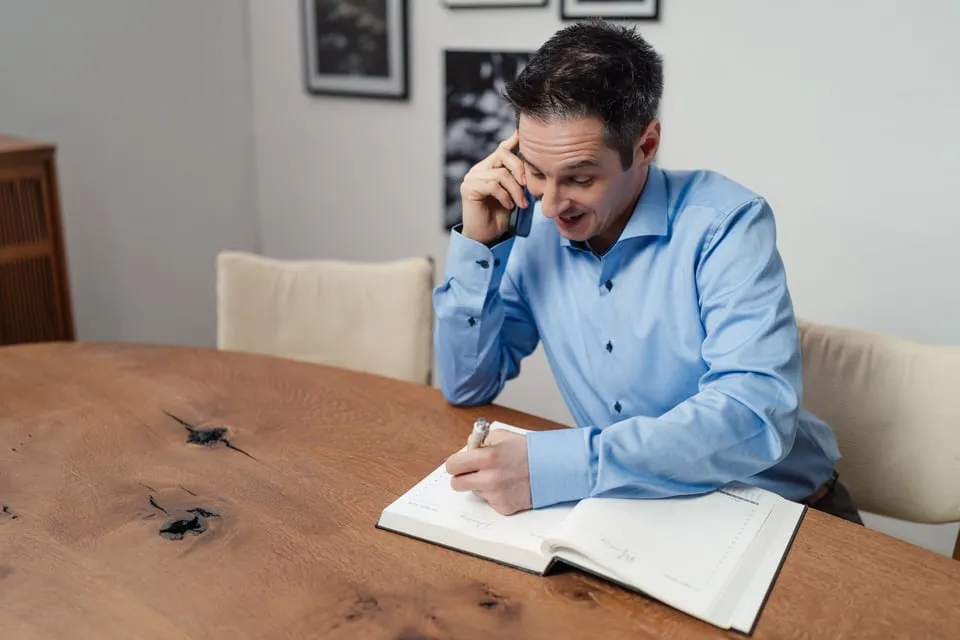 Alex Pippir telefoniert ruhig und macht sich Notizen